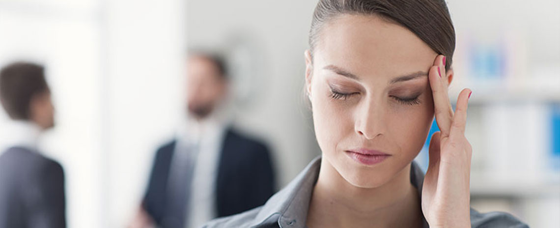 Woman holding her head with extreme migraine